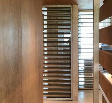 Wooden room divider with horizontal louvers in living area