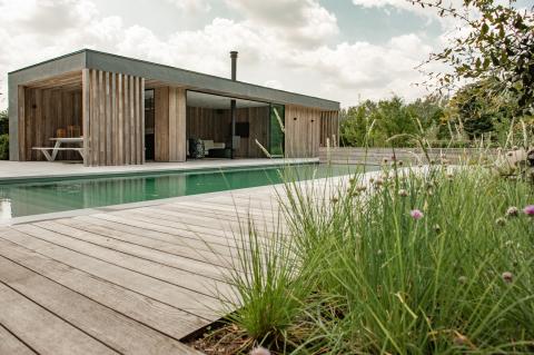 Modernes Poolhaus und Holzdeck aus vorvergrauter Thermoesche