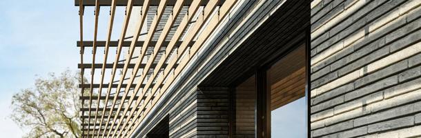 Struktureller Sonnenschutz mit Holzlamellen an der Fassade