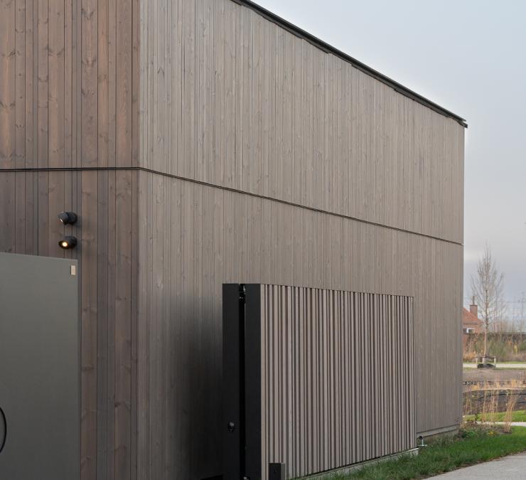 Houten bijgebouw en schuifpoort in thermisch hout afgewerkt in taupe kleur