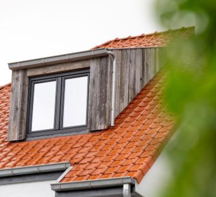 Timber-frame house with dormer window cladded with barnwood