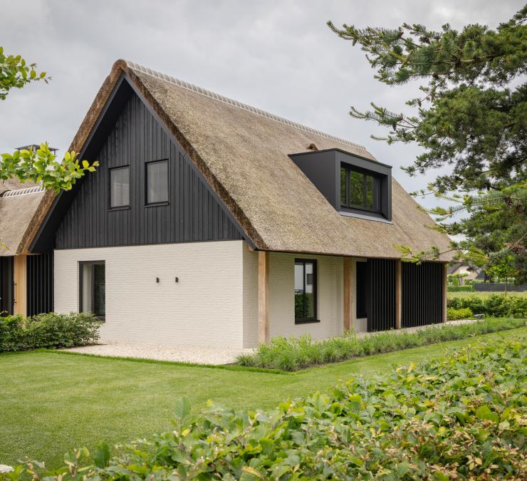 Zwarte topgevel in combinatie met rietdak en witte muren