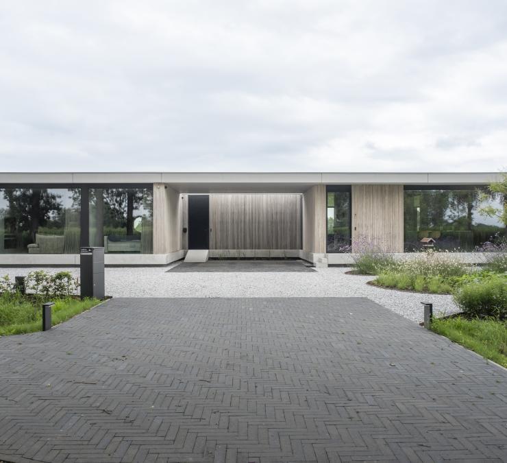 Bungalow industriel en béton agrémenté par une façade en bois pour un aspect chaleureux